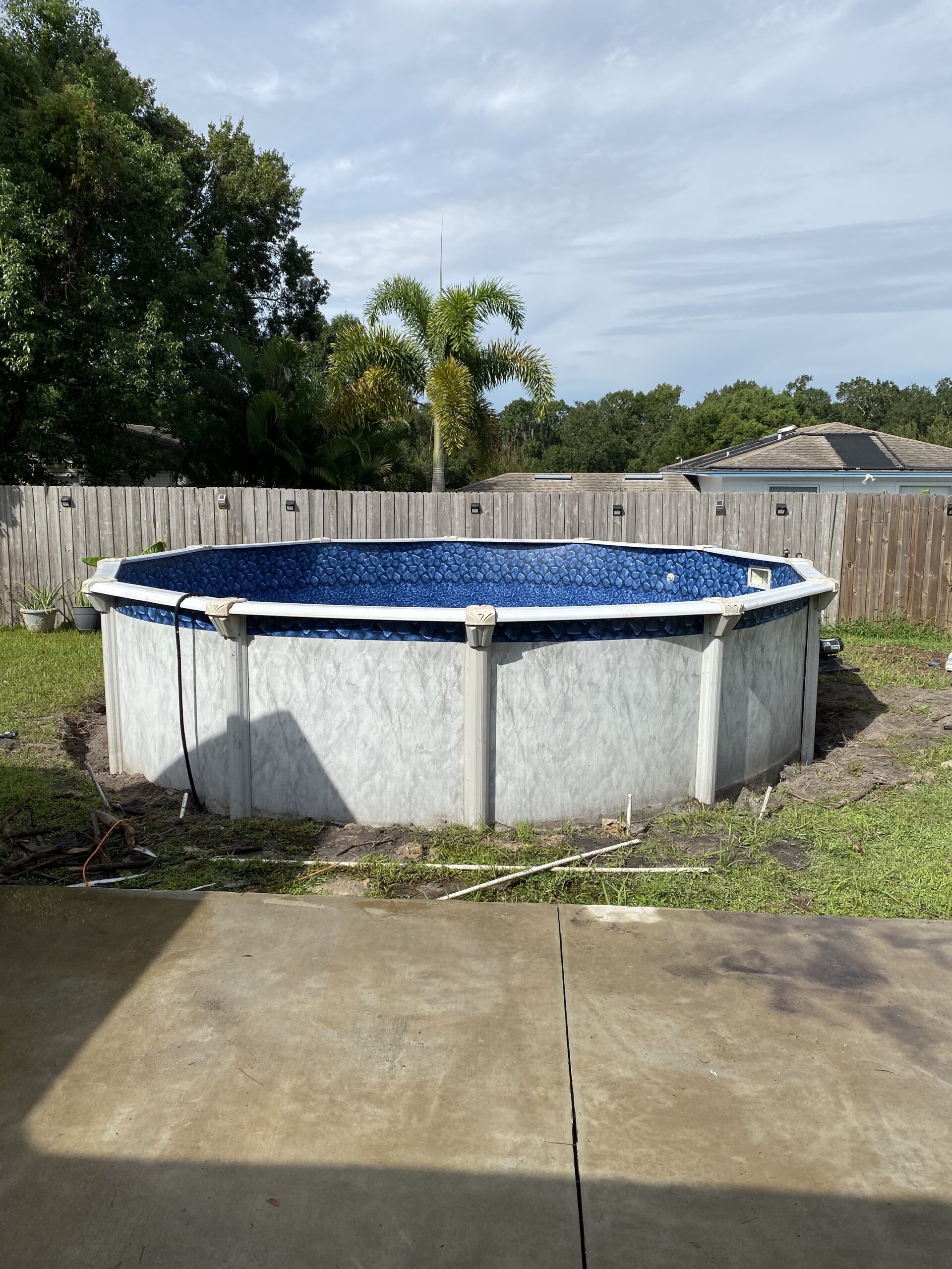 Above ground swimming pool installed with irrigation lines cut and marked around it