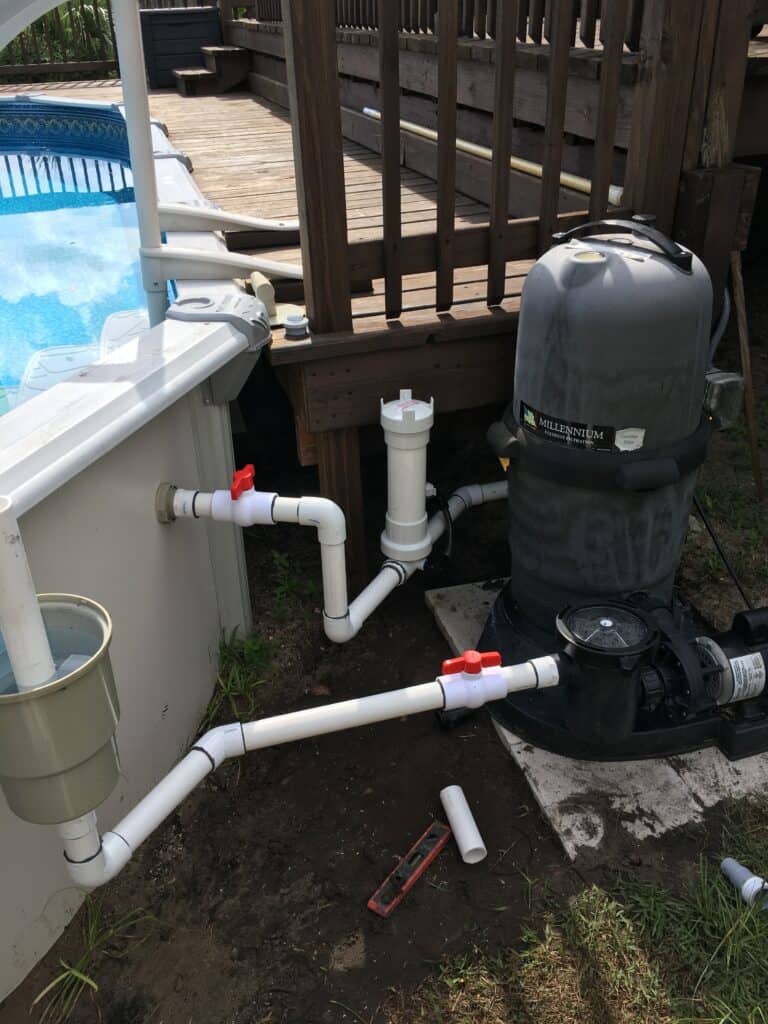 above ground pool pump and filter next to a wooden pool deck