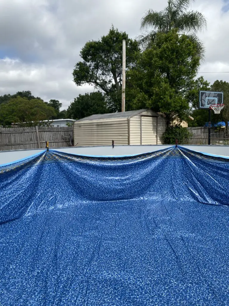 Above ground pool liner temporarily clipped to the wall during installation