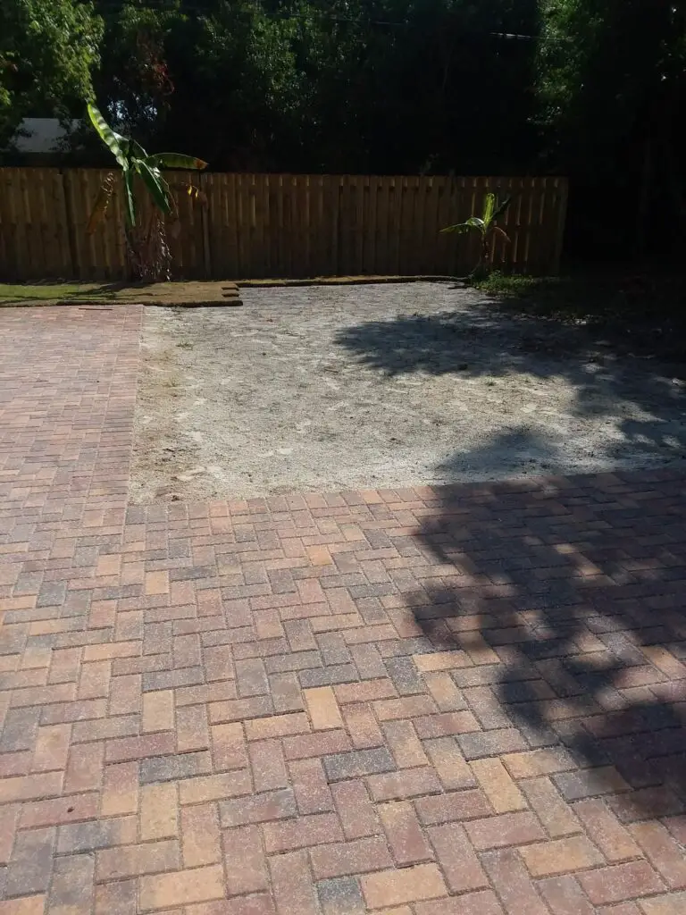 Open space in a backyard next to pavers for an oval above ground pool