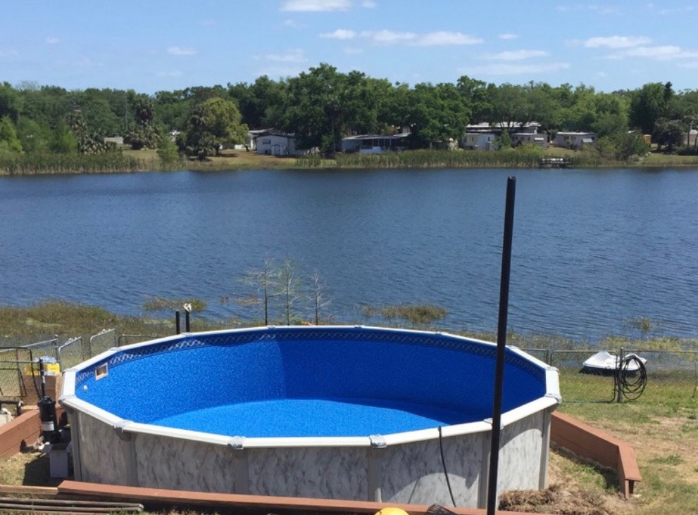 21' round above ground swimming pool next to a lake