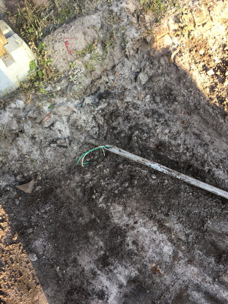 Exposed electric wire in broken conduit found when digging for an above ground pool installation