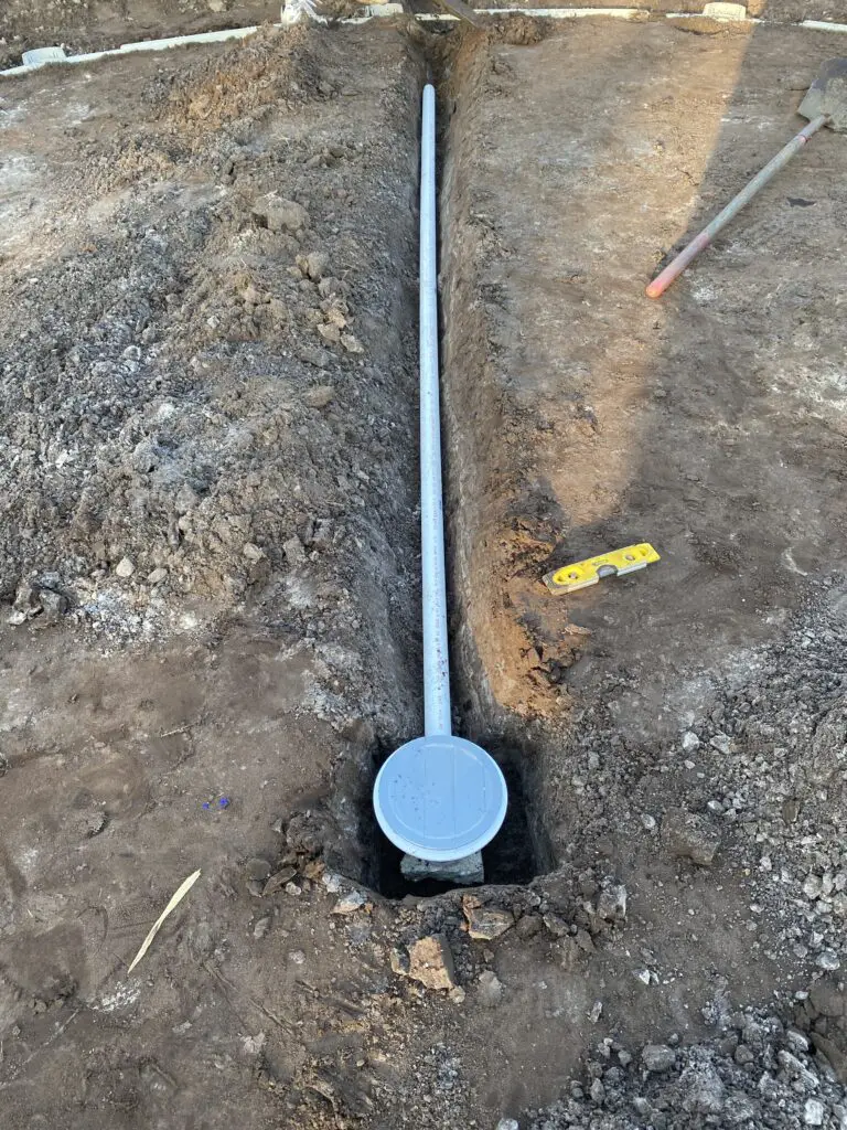 Main drain set with piping before being buried in place of an above ground swimming pool