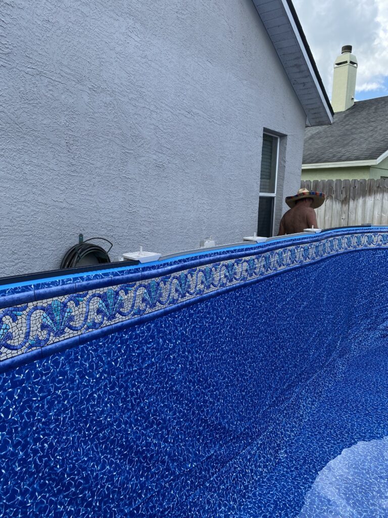J-hook type above ground pool liner is set in place on top of the pool wall 