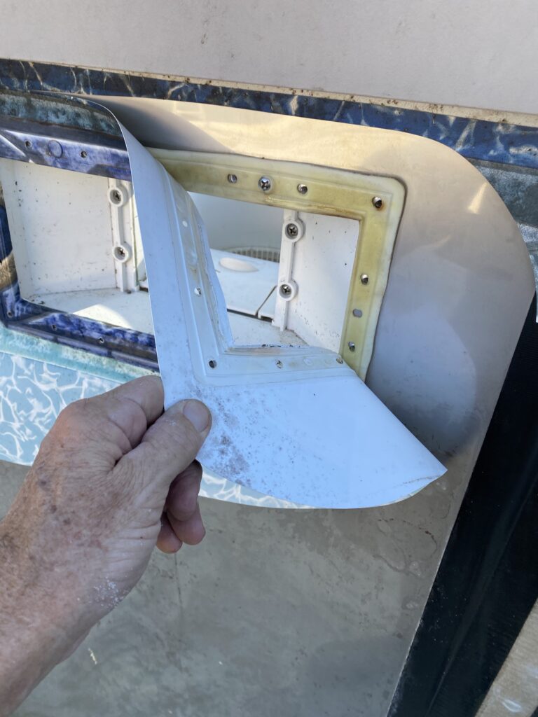 Pulling off the old liner from the skimmer gasket of an above ground pool