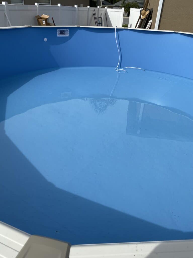 Plain blue overlap liner set in an above ground swimming pool and filling with water