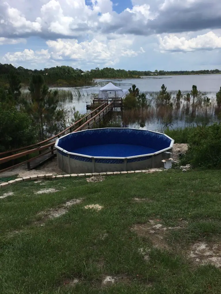 21' round above ground pool installed near a lake and a dock