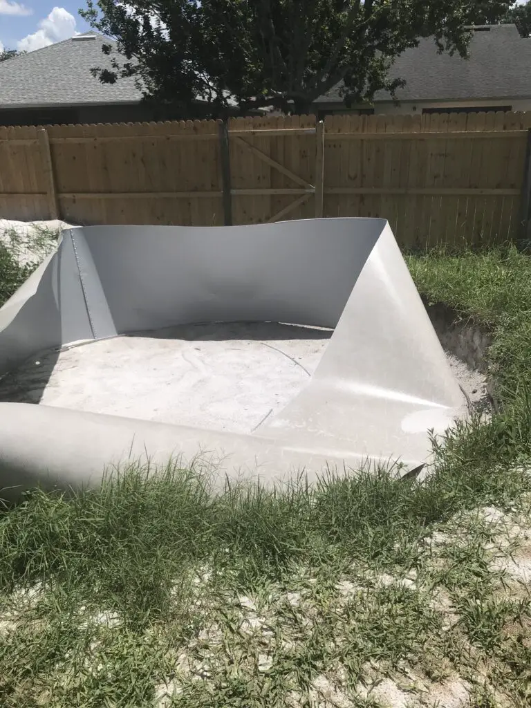 Above ground swimming pool wall fallen down due to a lack of support and wind