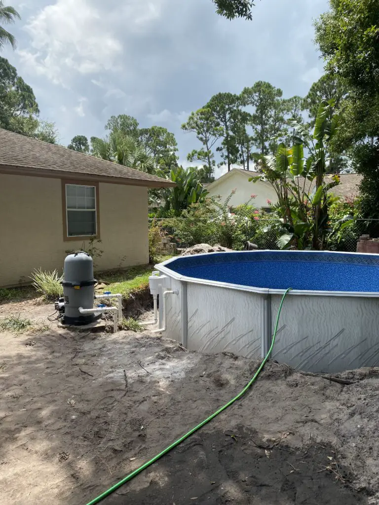 Above ground pool pump and filter set next to a semi inground pool before backfiing