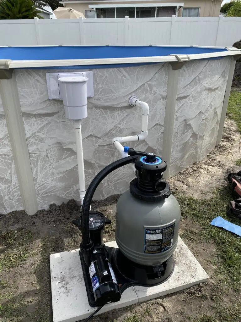 Pump and filter hardplumbed to an above ground pool and sitting on two patio stones