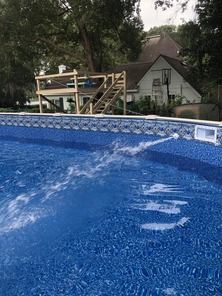 Water spraying out of a return jet into an above ground swimming pool