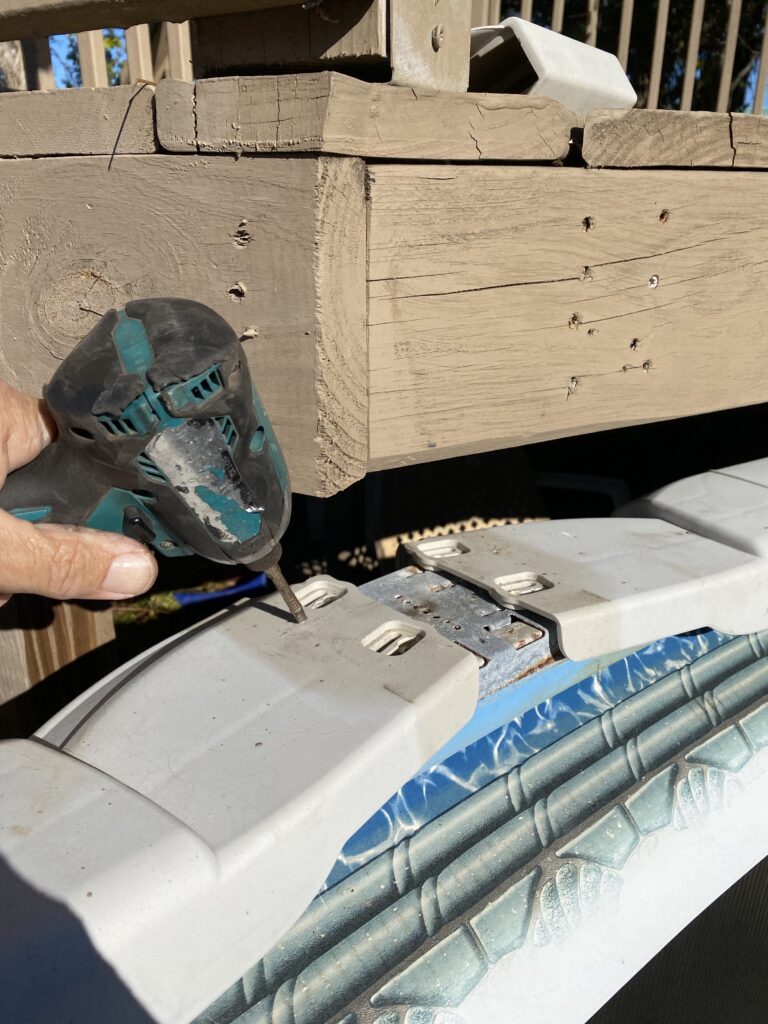 Makita drill trying to take a screw off of an above ground pool top rail with a deck in the way