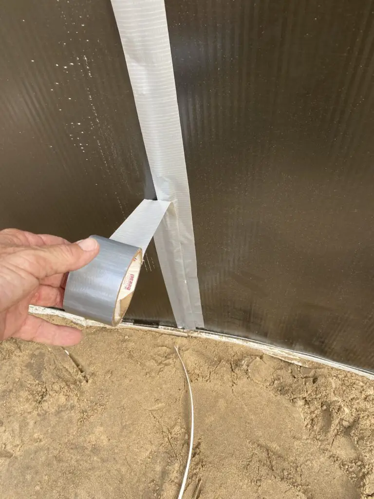 Applying duct tape to the wall bolts of an above ground swimming pool