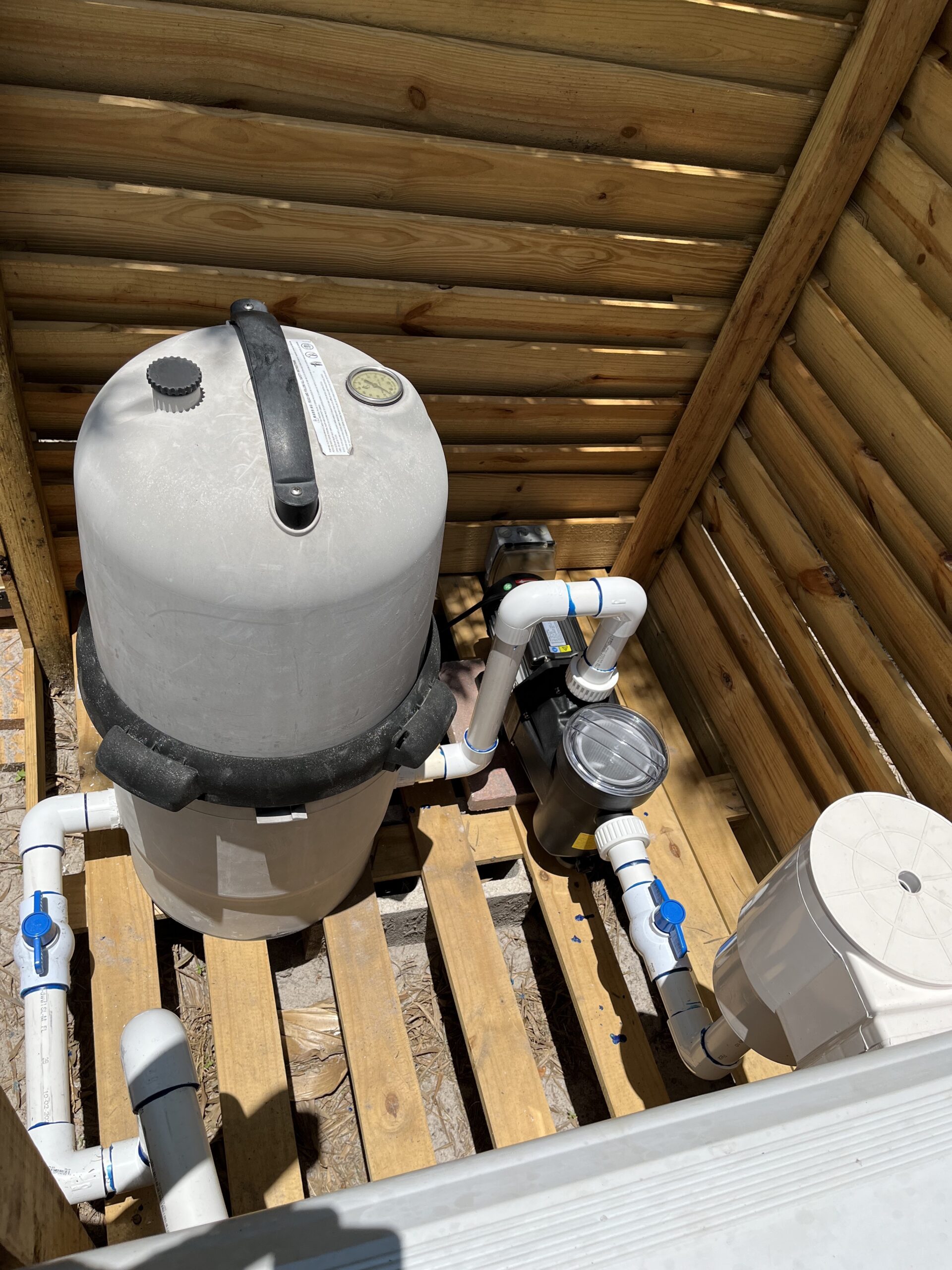 top view of above ground pool equipment encased in a housing